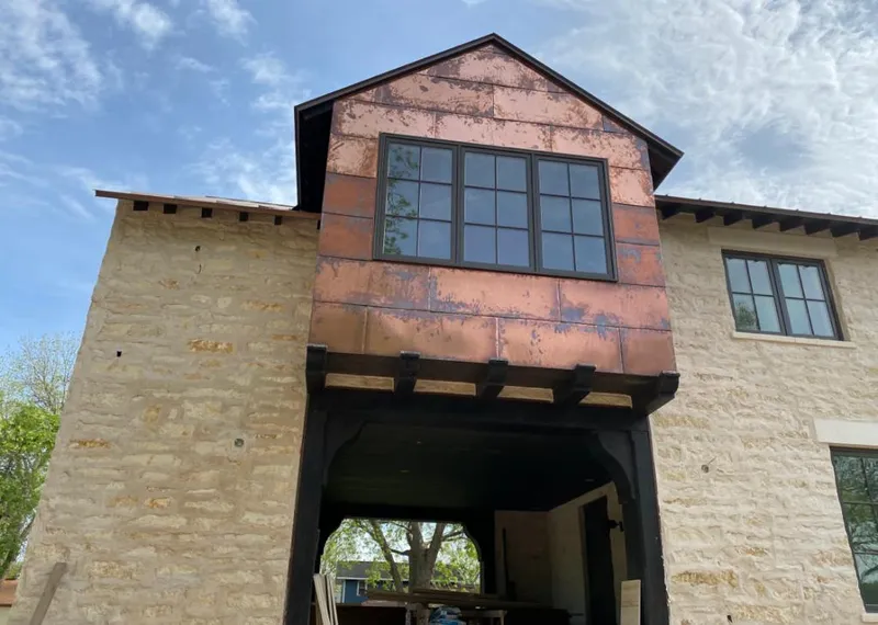 Copper metal panel facade on a stone building for Roof Repair in Royalton